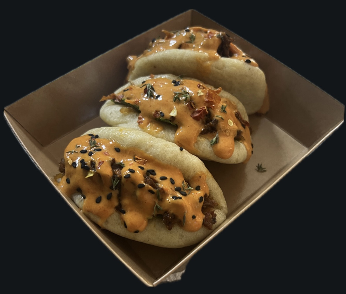 Three bao buns with orange sauce