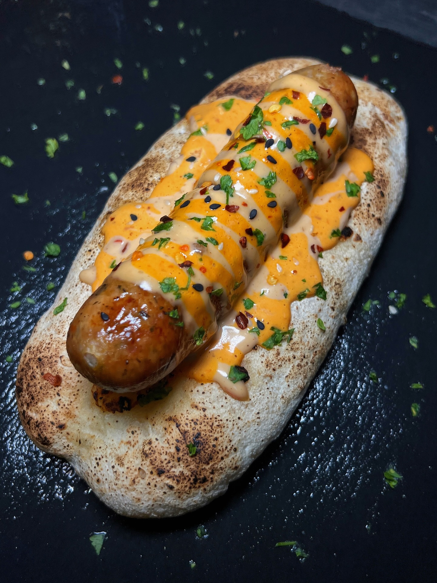Smoked sausage on flatbread with spicy drizzle